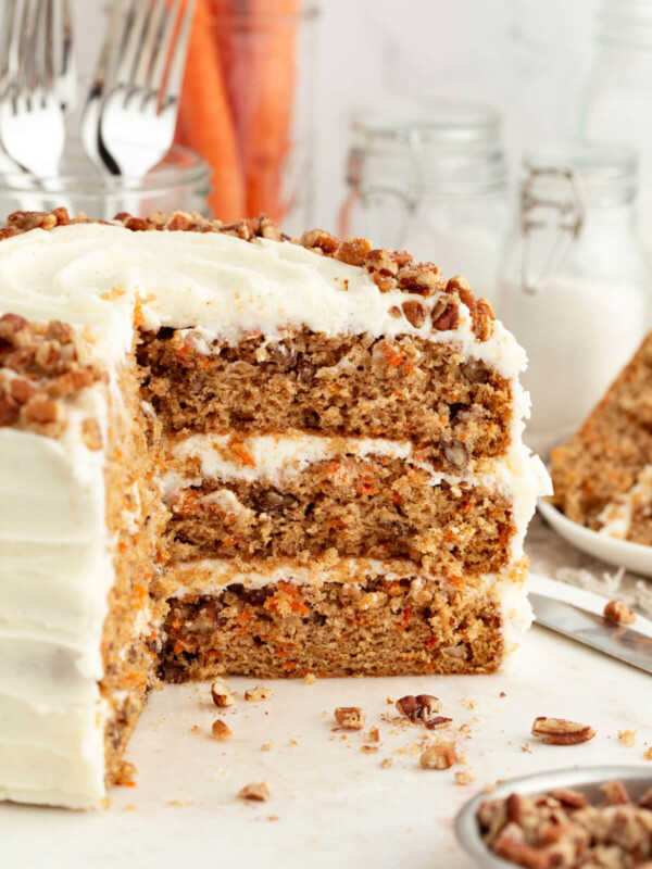 Three layer sourdough carrot cake with slices cut out of it.