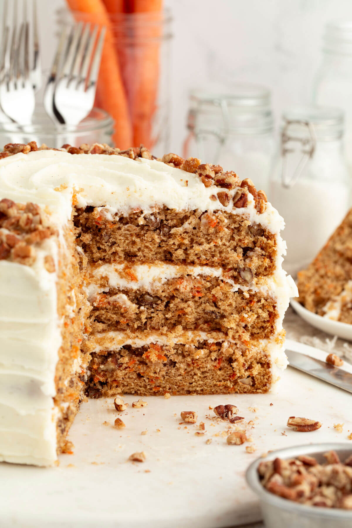 Three layer sourdough carrot cake with slices cut out of it.