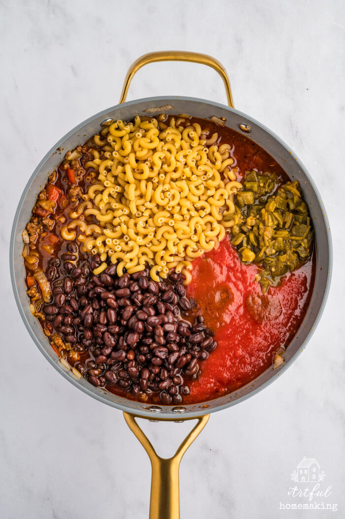 skillet with cooked beef mixture with tomatoes, chilies, black beans, and elbow macaroni