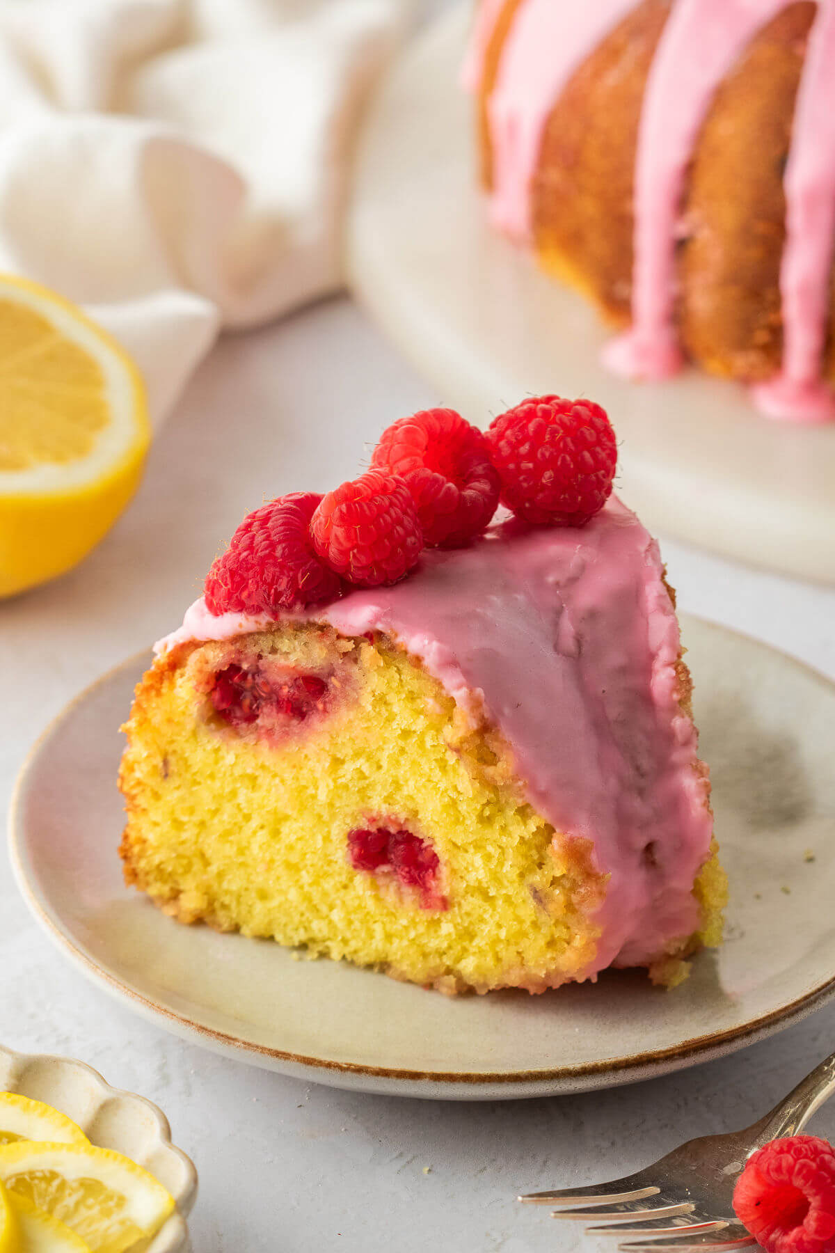 Lemon raspberry bundt cake slice on a plate.