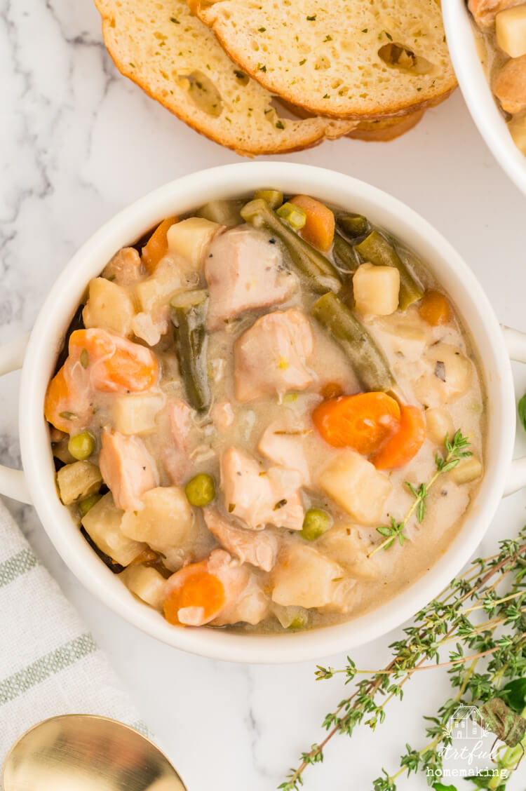 slow cooker chicken stew in a white bowl on a marble countertop