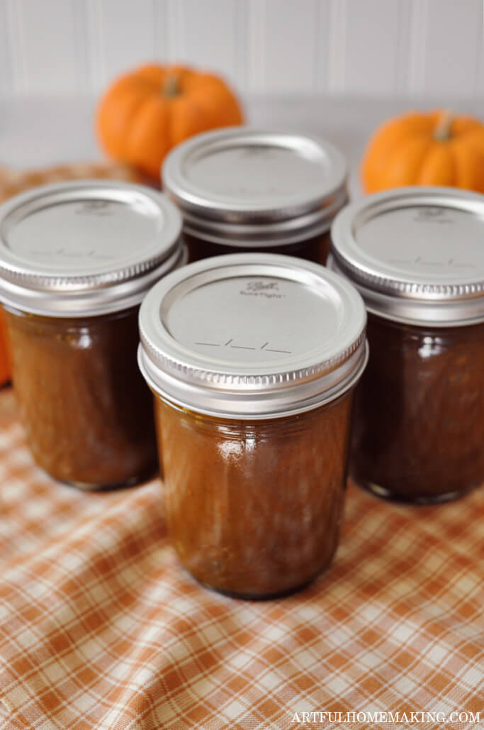 slow cooker pumpkin butter in mason jars on orange plaid cloth