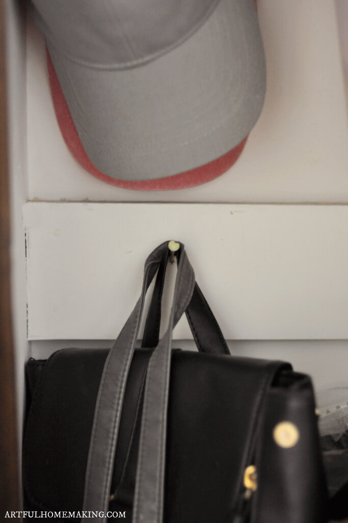 small bedroom closet organization hats and bags hanging on a nail