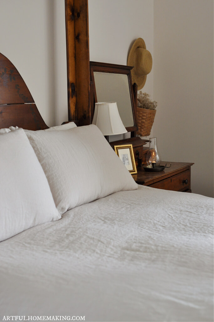 neutral bedding with straw hat and basket on wall