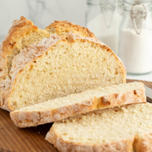 Loaf of sourdough Irish soda bread on a wooden board.