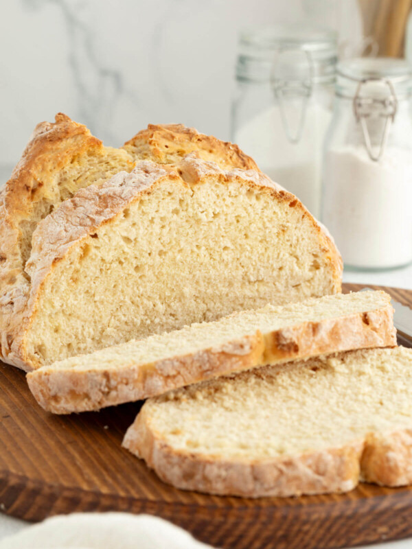 Loaf of sourdough Irish soda bread on a wooden board.