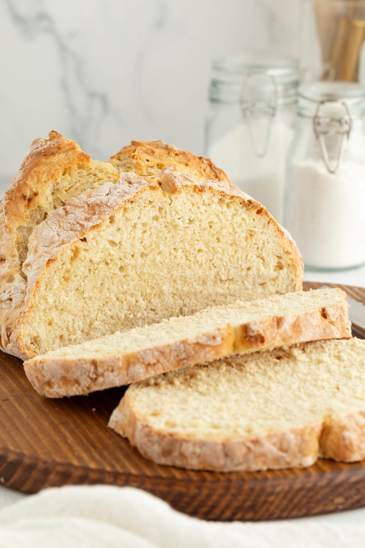 Loaf of sourdough Irish soda bread on a wooden board.