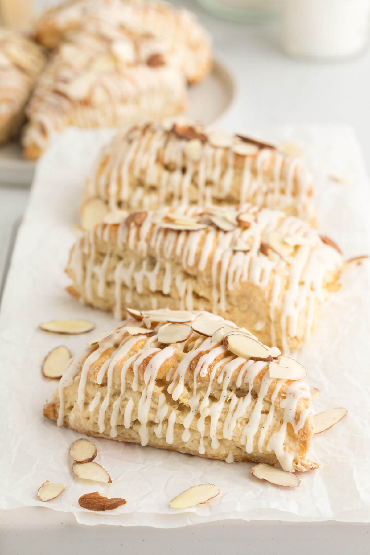top down view of three sourdough vanilla almond scones on a piece of white parchment paper