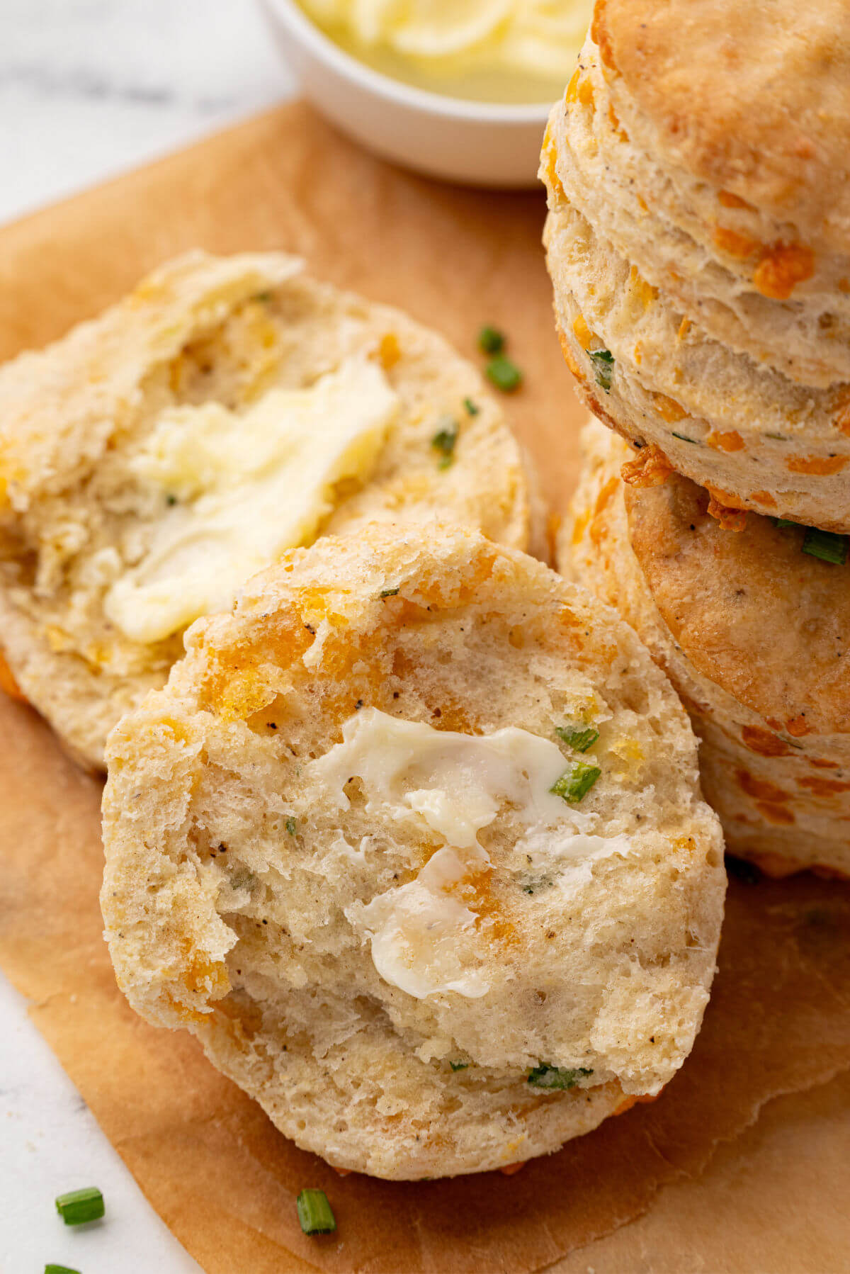 Sourdough cheddar biscuits with butter spread on them.