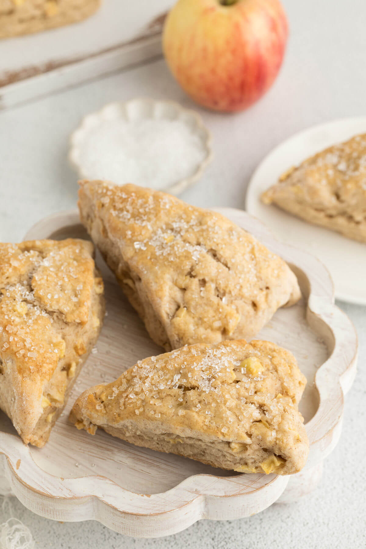 sourdough apple cinnamon scones on a white wooden plate.