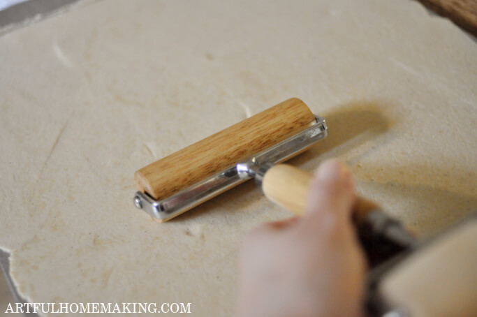 Rolling pin rolling out sourdough cracker dough.