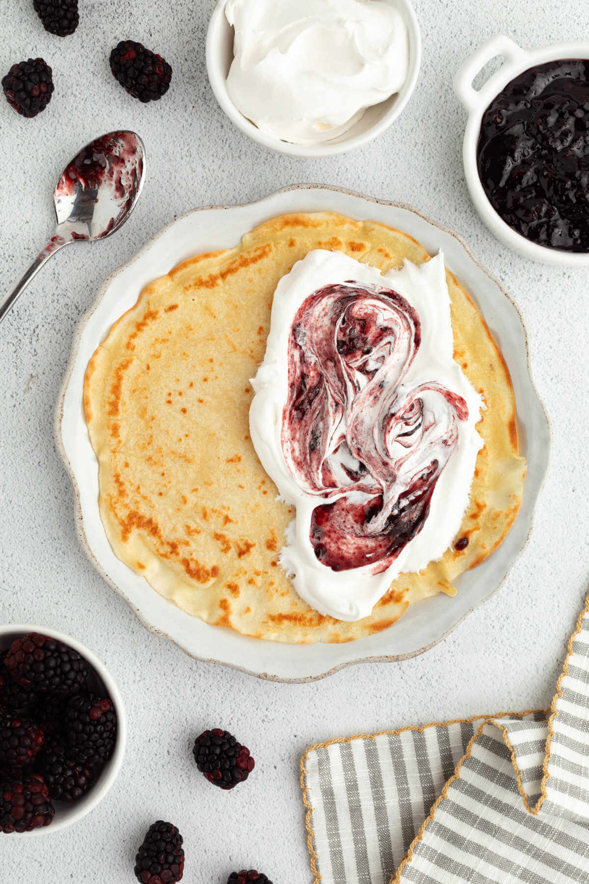 Sourdough crepes with whipped cream and berries on a plate.