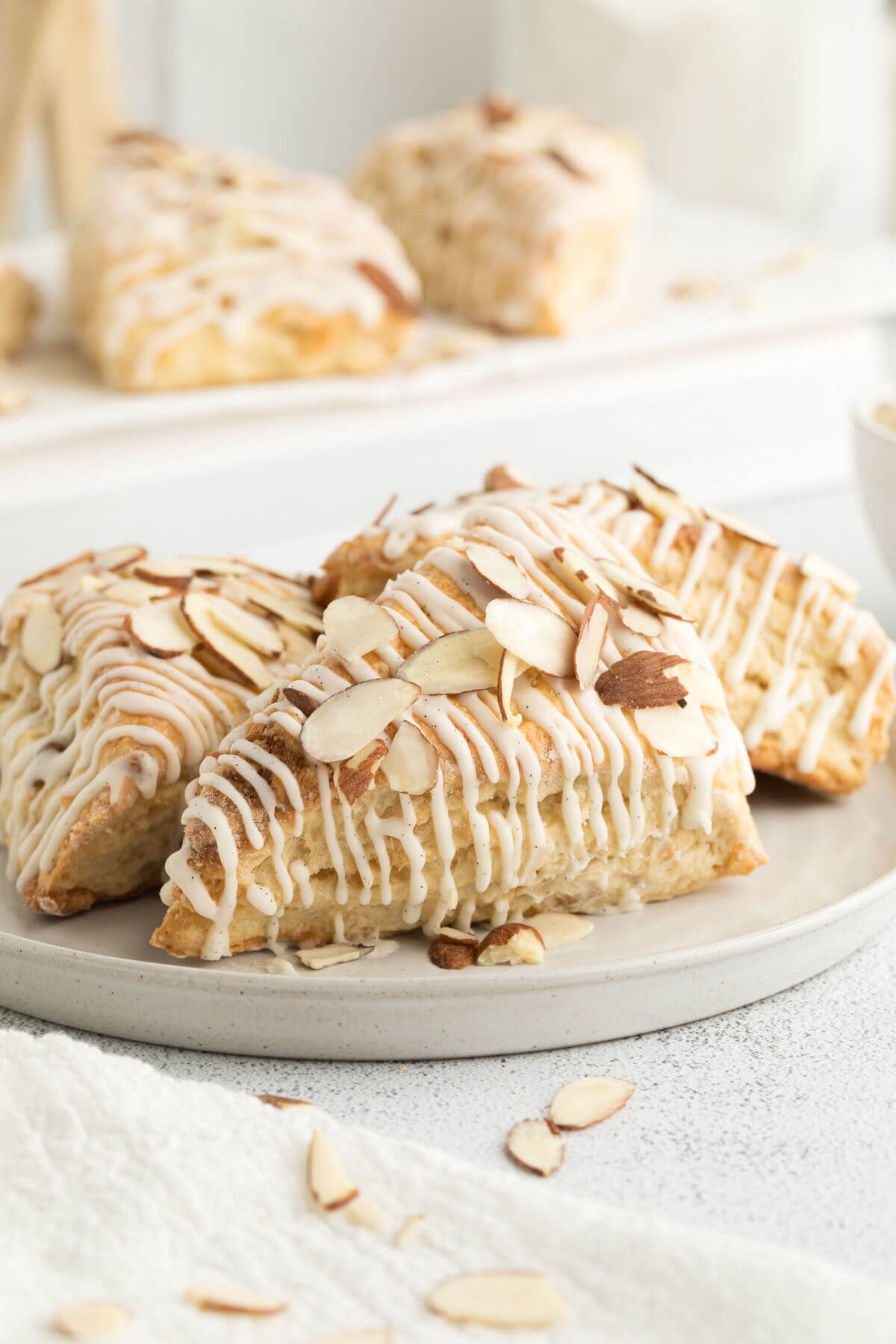side view of sourdough almond scones on a white plate