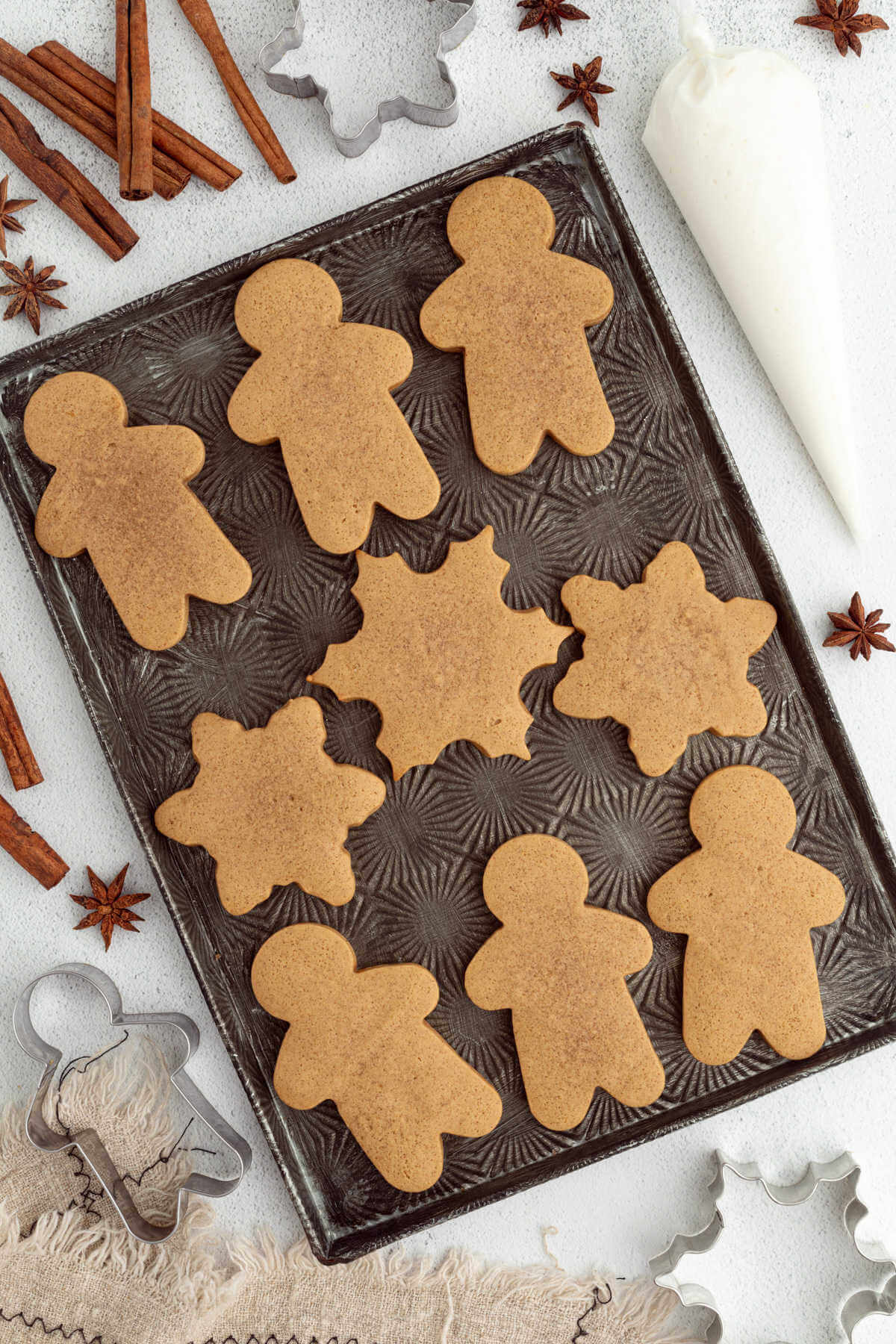 Baked sourdough gingerbread cookies on a baking sheet.