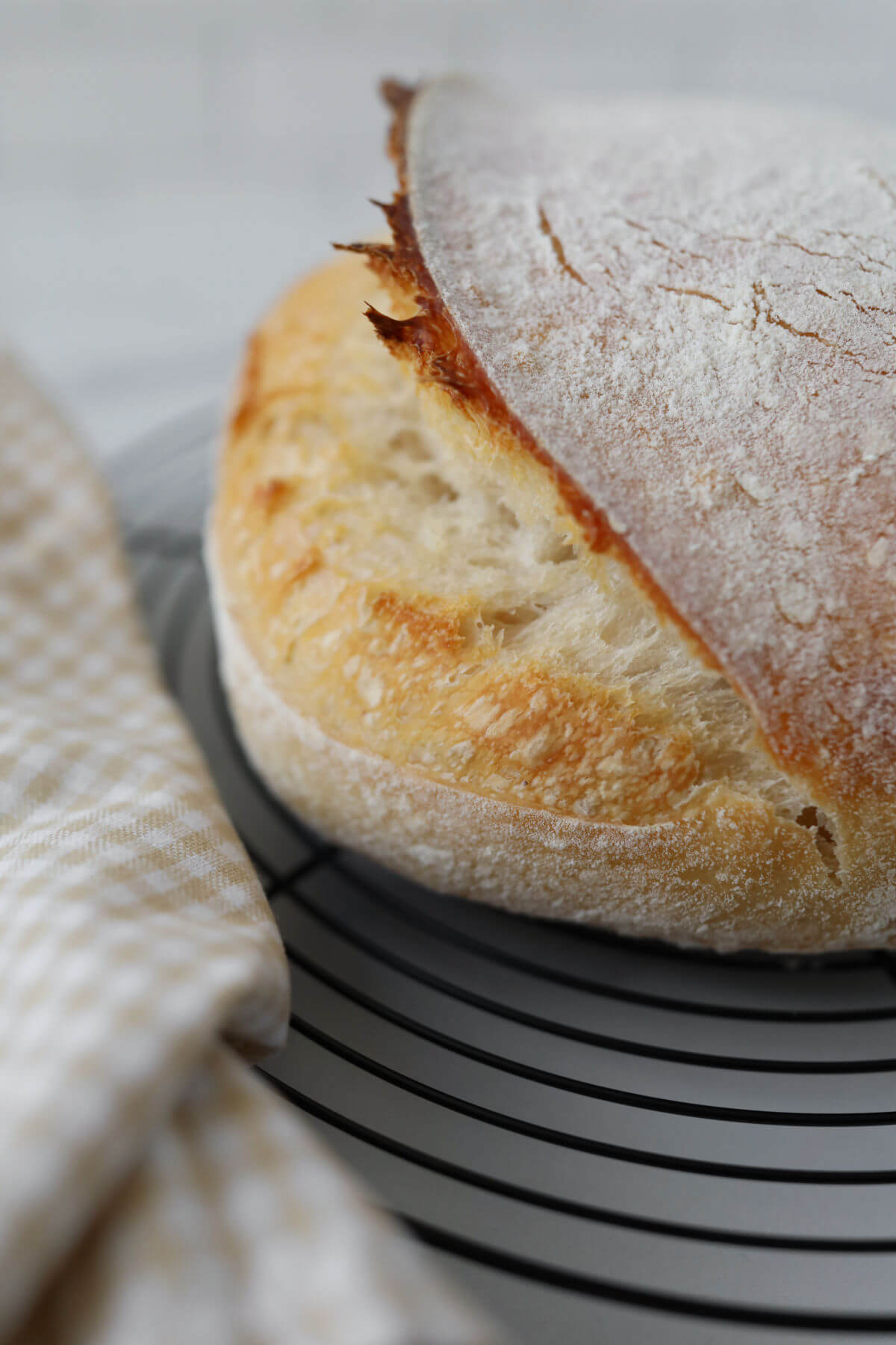 Sourdough artisan loaf with ear on a wire rack.