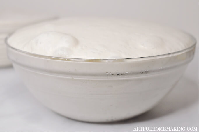 sourdough after bulk proofing has risen above rim of bowl and has large bubbles on top