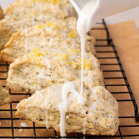 Drizzling lemon glaze on top of sourdough lemon poppy seed scones.