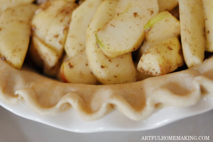 fluted edge of pie crust with apple filling in the crust