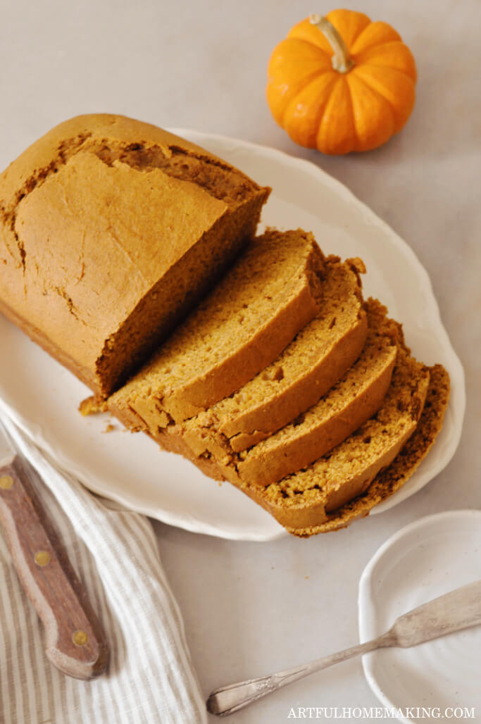 sourdough pumpkin bread on a white platter, sliced.