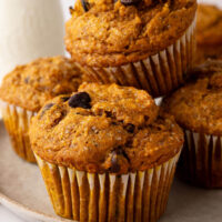 Pile of sourdough pumpkin chocolate chip muffins on a plate.