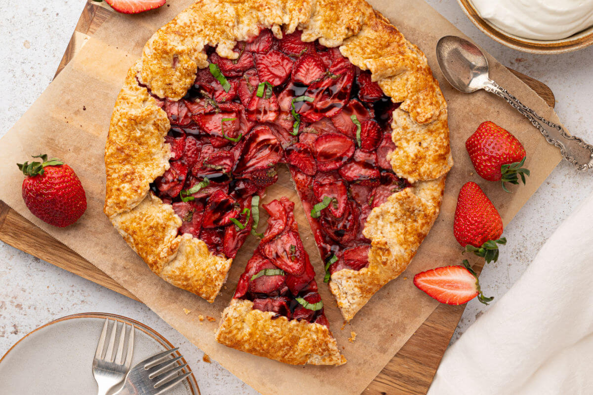 Sourdough galette with fresh strawberry filling on a piece of parchment paper after baking.