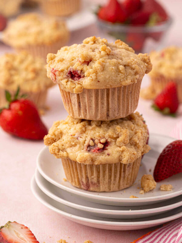 Two sourdough strawberry muffins with streusel topping on a plate.