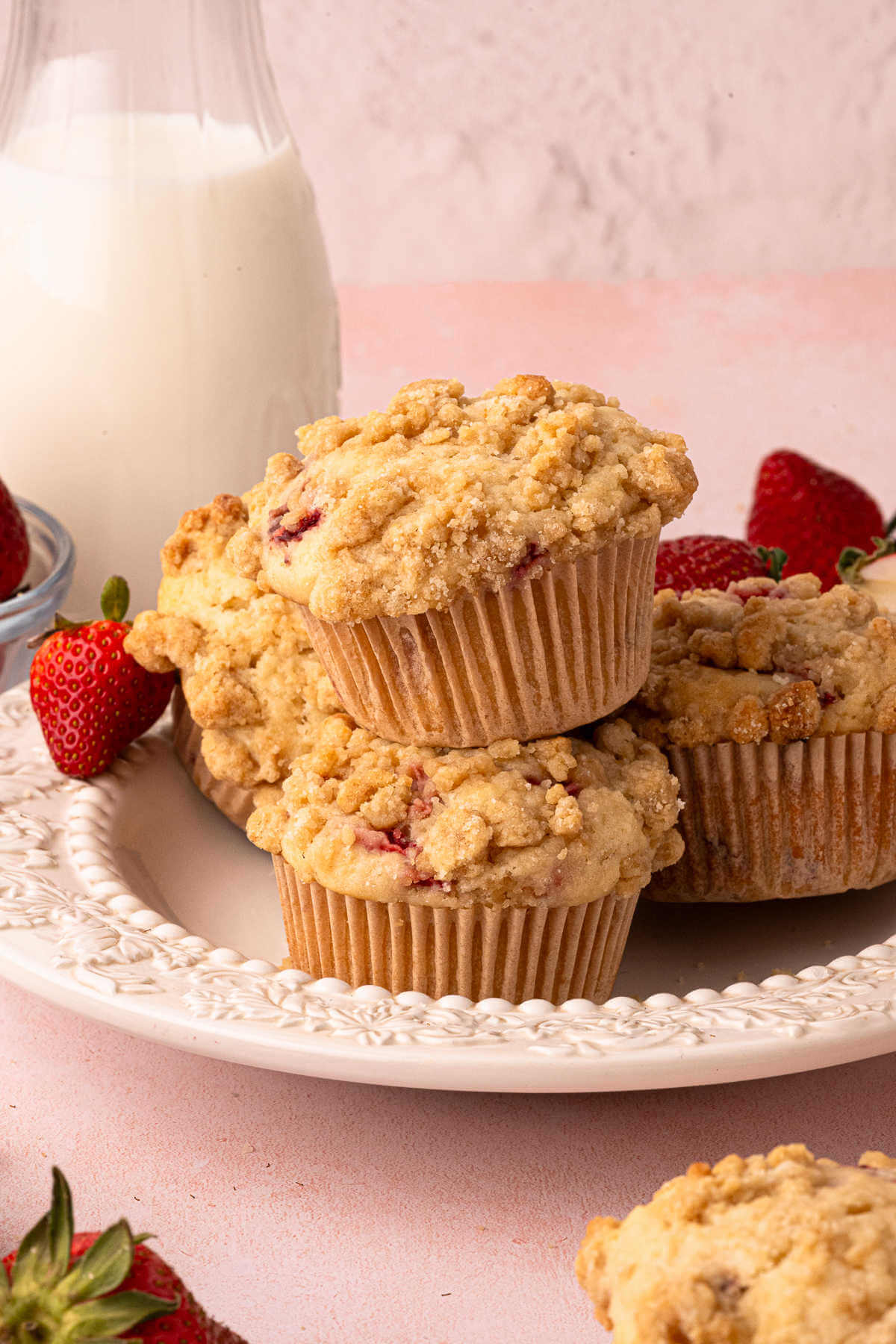 A pile of sourdough strawberry muffins on a plate for serving.