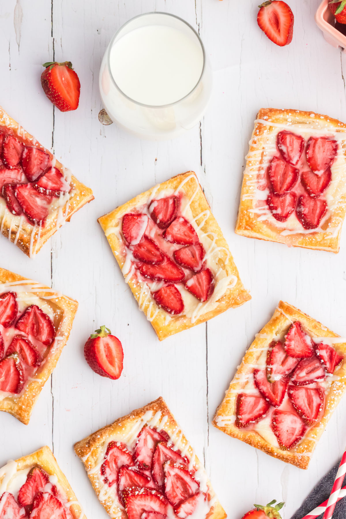 top down view of strawberry cream cheese danishes on a white wood background