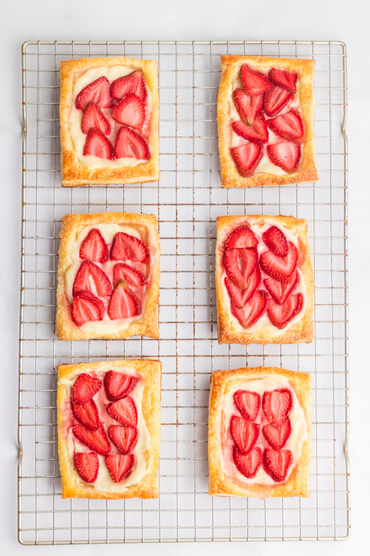 top down view of strawberry cream cheese danish pastries on a wire cooling rack