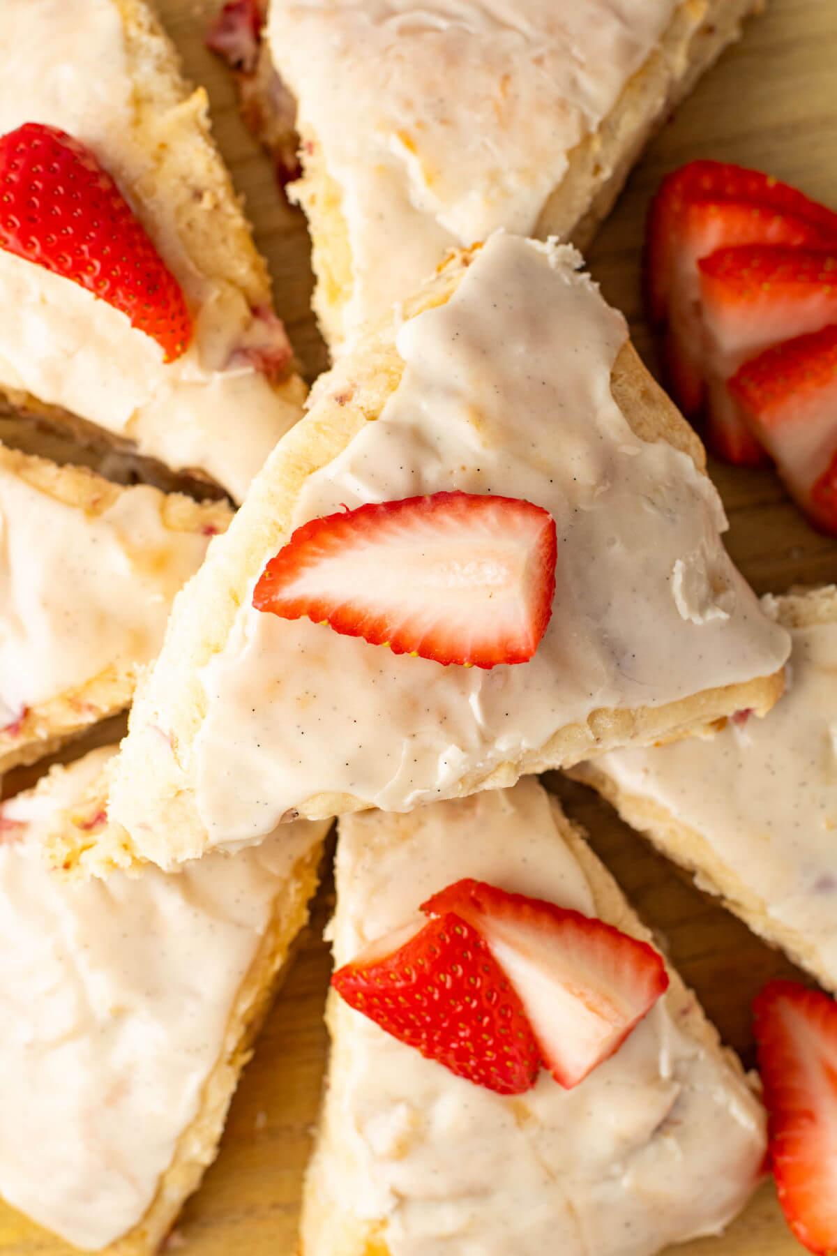 Sliced strawberry scones with fresh strawberries on top.