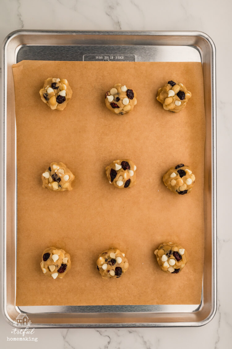 white chocolate macadamia cranberry cookies on parchment lined baking sheet